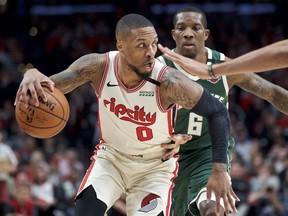 Le garde des Portland Trail Blazers Damian Lillard dribble autour du garde des Milwaukee Bucks Eric Bledsoe lors d'un match la saison dernière.