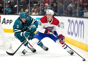 Les Canadiens Rafael Harvey-Pinard contrôlent la rondelle contre le défenseur des Sharks Matt Benning lors d'un match au SAP Center en février.