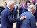 Le président américain Joe Biden pose sa main sur le dos du roi Charles III de Grande-Bretagne alors qu'ils marchent dans le Quadrangle après la cérémonie de bienvenue au château de Windsor lundi.