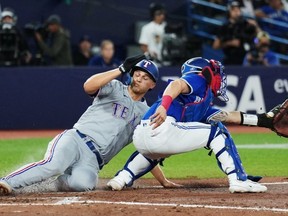 Corey Seager (à gauche) des Texas Rangers a devancé le tag du receveur des Blue Jays Tyler Heineman au Rogers Centre hier soir.  Les Jays ont perdu 6-3.  Nathan Dennette/La Presse Canadienne