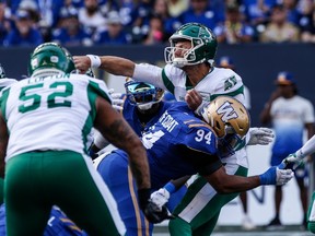 Le quart-arrière des Roughriders de la Saskatchewan, Jake Dolegala (9), est frappé par Jackson Jeffcoat (94), des Blue Bombers de Winnipeg, au cours de la première moitié du match de football de la LCF à Winnipeg, le samedi 9 septembre 2023.