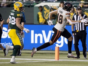 Adam Konar (38 ans) des Elks d'Edmonton regarde Justin McInnis (18 ans) des Lions de la Colombie-Britannique marquer un touché lors de la première moitié de l'action de la LCF au Stade du Commonwealth, à Edmonton, le vendredi 22 septembre 2023.