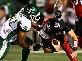 Le joueur de ligne défensive des Roughriders de la Saskatchewan, Christian Albright (97 ans), déchire le maillot du quart-arrière des Redblacks d'Ottawa Dustin Crum (18 ans) alors qu'il le limoge, lors de la première mi-temps d'un match de football de la LCF à Ottawa, le vendredi 22 septembre 2023.