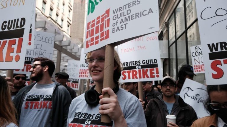 NEW YORK CITY - MAY 03: Members of the Writers Guild of America (WGA) East hold signs as they walk for the second day on the picket-line outside of Netflix's New York office on May 03, 2023 in New York City. WGA members were out on the first day of a Hollywood voters strike after the board of directors for the Writers Guild of America, which includes West Coast and East Coast branches, voted unanimously to call for a walkout. Negotiations between a top guild and a trade association that represents Hollywood’s top studios failed to avert the first walkout in more than 15 years. Union members have stated that they are not being paid fairly in the streaming era and are seeking pay increases and structural changes to the business model.  (Photo by Spencer Platt/Getty Images)