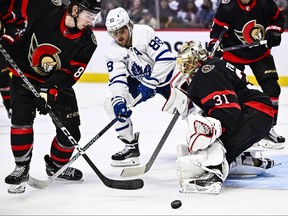 William Nylander (88 ans) des Maple Leafs cherche la rondelle tandis qu'Anton Forsberg et Jake Sanderson des Sénateurs d'Ottawa se défendent lors de la troisième période d'action pré-saison à Ottawa, le dimanche 24 septembre 2023.