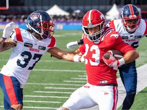 L'arrière des Stampeders de Calgary William Langlais est poussé hors des limites du terrain par le demi défensif des Alouettes de Montréal Wesley Sutton et le secondeur Tyrice Beverette au stade McMahon de Calgary, le samedi 23 septembre 2023.