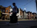 Une personne passe devant une rangée de maisons à Toronto.