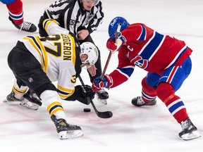 Le joueur des Bruins en blanc affronte le joueur du Tricolore en rouge alors que le juge de touche se prépare à lancer la rondelle au Centre Bell.