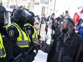 Alors que des milliers de manifestants envahissaient les rues autour de la Colline du Parlement au début de 2022, bon nombre d’entre eux l’ont fait avec un téléphone à la main.  Un manifestant enregistre une ligne de police avec son téléphone alors que la police se déplace pour débarrasser le centre-ville d'Ottawa, près de la Colline du Parlement, des manifestants après des semaines de manifestations le samedi 19 février 2022.