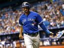 Chris Colabello #15 des Blue Jays de Toronto (L) célèbre avec son coéquipier Ryan Goins #17 après avoir marqué lors de la deuxième manche d'un match contre les Rays de Tampa Bay le 2 octobre 2015 au Tropicana Field de Saint-Pétersbourg, en Floride.