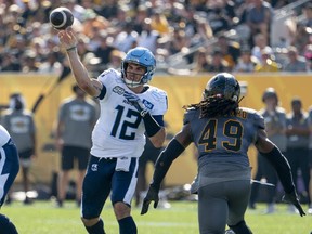 Le quart-arrière des Argonauts de Toronto Chad Kelly (12) se lance lors d'un match de la LCF contre les Tiger-Cats de Hamilton lors de la Classique annuelle de la fête du Travail à Hamilton, en Ontario.  le lundi,