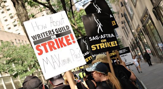 NEW YORK, NEW YORK - JULY 20: Members of the Writers Guild of America and SAG-AFTRA hold up signs outside of 30 Rockefeller Plaza on July 20, 2023 in New York City. Members of SAG-AFTRA, Hollywood's largest union which represents actors and other media professionals, have joined striking WGA (Writers Guild of America) workers in the first joint walkout against the studios since 1960. The strike could shut down Hollywood productions completely with writers in the third month of their strike against the Hollywood studios.  (Photo by Cindy Ord/Getty Images)