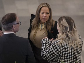 Lich, au centre, discute avec le député provincial Drew Barnes, Cypress Medicine Hat, à gauche, et d'autres avant le budget 2023, à Edmonton