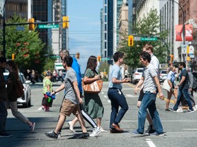 Un groupe de personnes traverse une intersection au centre-ville de Vancouver.