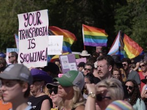 Des gens manifestent devant le Palais législatif de Regina, le samedi 2 septembre 2023.