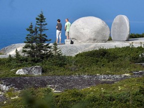 Les visiteurs regardent l'océan depuis le mémorial du vol 111 de Swissair à Whalesback, près de Peggy's Cove, en Nouvelle-Écosse, le jeudi 30 août 2018.