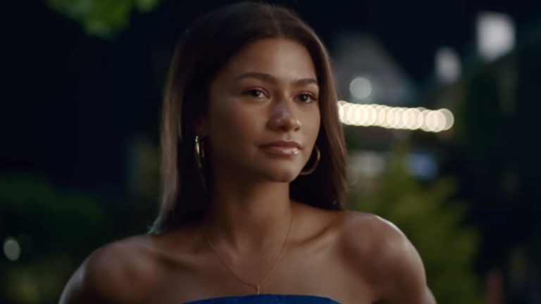 Zendaya looking forward while wearing a strapless blue dress in Challengers.