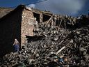 Un survivant du tremblement de terre marche parmi les débris des maisons détruites dans le village d'Ighermane, près d'Adassil, au centre du Maroc.