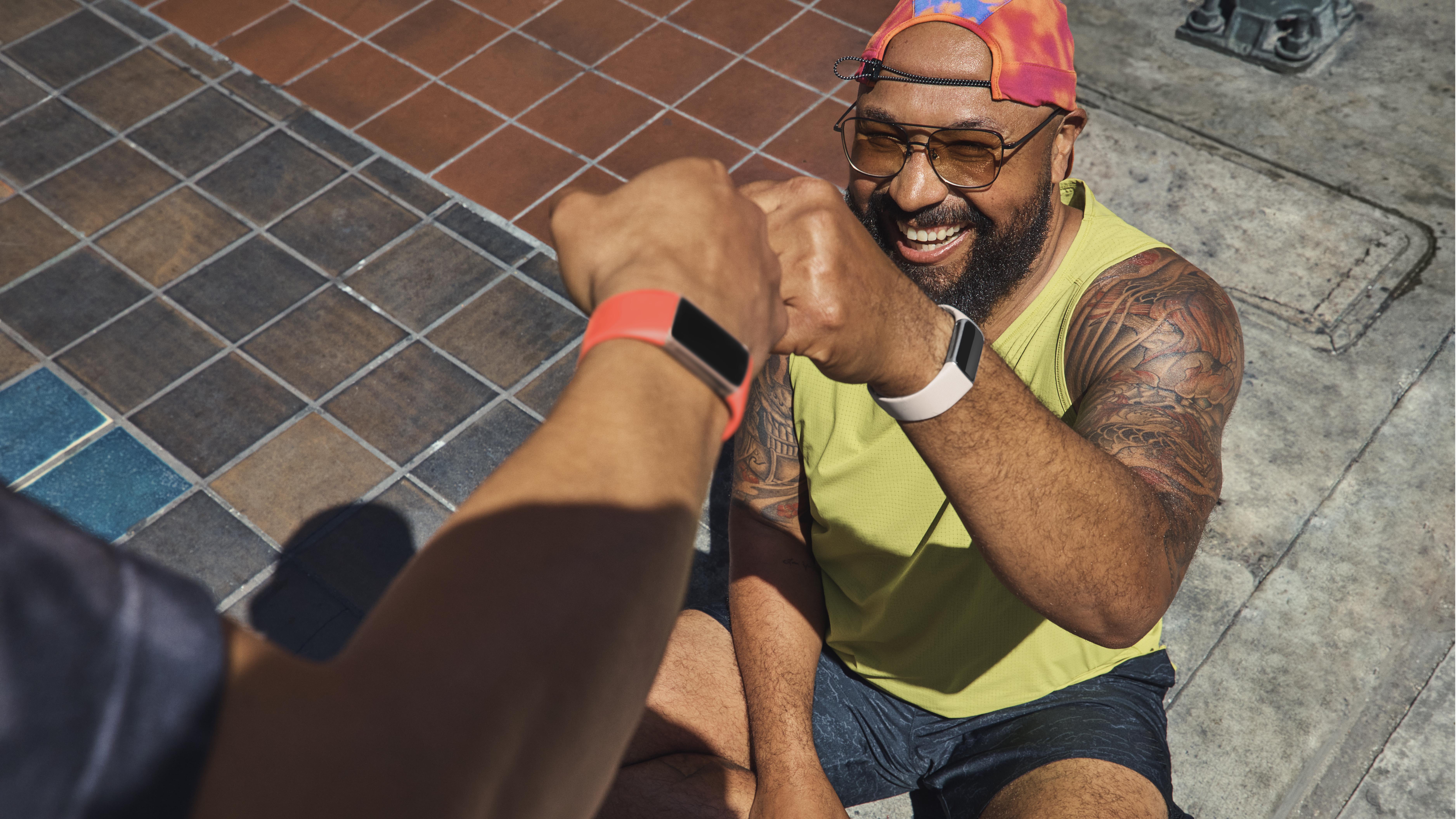 une photo d'un homme assis par terre portant un Fitbit Charge 6