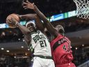 Le garde des Milwaukee Bucks Jrue Holiday (21 ans) saisit un rebond contre l'attaquant des Raptors de Toronto Pascal Siakam. 