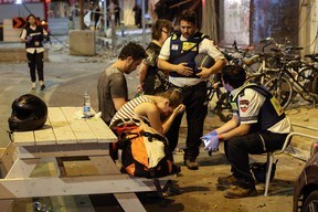 Une jeune femme réagit alors qu'elle s'adresse aux sauveteurs israéliens à Tel Aviv, après qu'un bâtiment a été touché par une roquette tirée par des militants palestiniens depuis la bande de Gaza, le 7 octobre 2023.