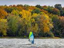 Les feuilles changeantes offrent un décor aux véliplanchistes au large du parc-nature de l'Anse-à-l'Orme, à Pierrefonds-Roxboro, le 7 octobre 2022.