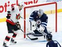 L'attaquant Jiri Smejkal, vu ici en train de regarder un rebond tandis que le gardien des Jets Connor Hellebuyck effectue un arrêt lors du match préparatoire de jeudi à Winnipeg, a connu un solide camp d'entraînement avec les Sénateurs.