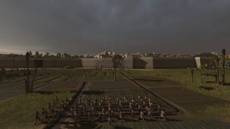 Total War Pharaoh review: A group of slingshoters stand before a broken city wall as enemy units pour our for a counterattack.