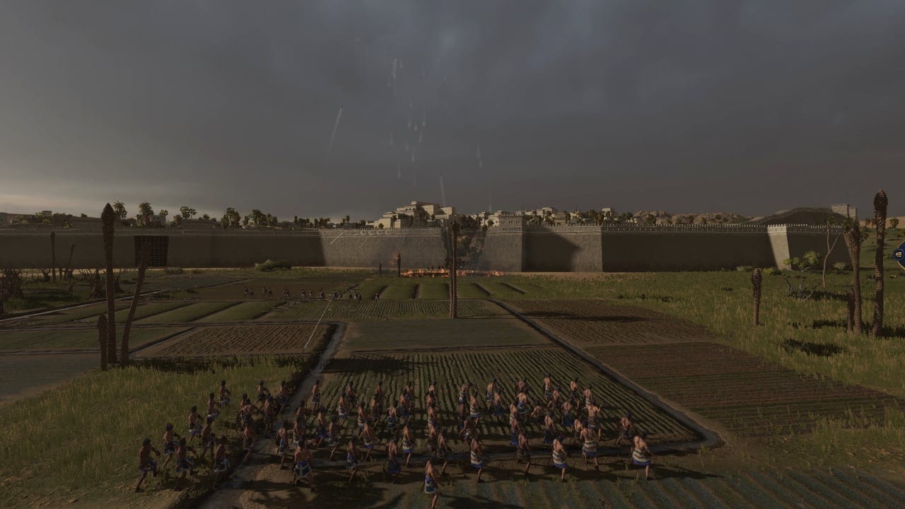 Total War Pharaoh review: A group of slingshoters stand before a broken city wall as enemy units pour our for a counterattack.