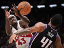 Pascal Siakam des Raptors de Toronto, à gauche, perd le contrôle du ballon après avoir été victime d'une faute de Trey Lyles des Sacramento Kings lors de la première moitié d'un match préparatoire de la NBA à Vancouver le dimanche 8 octobre 2023.