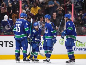 Les Canucks de Vancouver Ilya Mikheyev, Conor Garland, Jack Rathbone et Brock Boeser (de gauche à droite) célèbrent le but de Garland contre les Sabres de Buffalo lors d'un match de la LNH le 22 octobre 2023 au Rogers Arena.