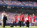 Les nouveaux Canadiens participent à une cérémonie de citoyenneté pour la fête du Canada avant le début d'un match des Blue Jays de Toronto, à Toronto, le 1er juillet 2023.