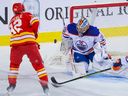 Le gardien de but des Oilers d'Edmonton, Jack Campbell, arrête un tir du défenseur des Flames de Calgary Jordan Oesterle au Scotiabank Saddledome à Calgary, le 29 septembre 2023.