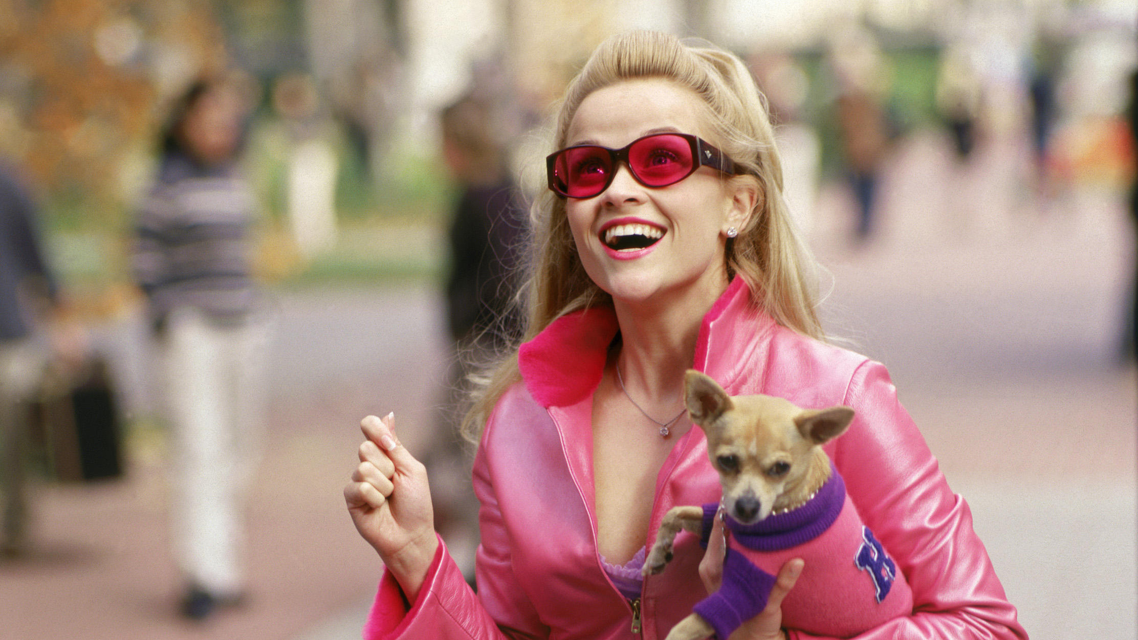 Reese Witherspoon dans le rôle d'Elle Woods (vêtue de rose) tenant son chien Bruiser dans Legally Blonde