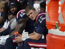 Le quart-arrière des New England Patriots Mac Jones, à droite, est assis sur le banc après avoir été retiré pendant la seconde moitié d'un match de football de la NFL contre les New Orleans Saints, le dimanche 8 octobre 2023, à Foxborough, Massachusetts.