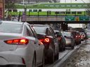 Un train GO passe au-dessus des véhicules alignés pour accéder à l'autoroute Gardiner à l'heure de pointe du soir au centre-ville de Toronto, le 22 janvier 2019. 