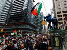 Des manifestants en soutien aux Palestiniens brandissent des drapeaux palestiniens lors d’une manifestation à Toronto, le 9 octobre 2023.