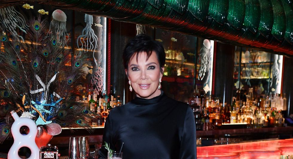 Kris Jenner portant une robe noire, posant devant avec une boisson rose à la main, devant l'étalage de tequila 818 au Mayfair Supper Club du Bellagio Resort Casino le 23 juin 2023 à Las Vegas, Nevada