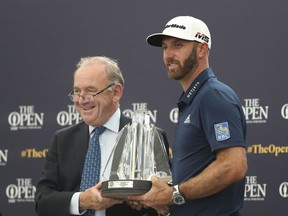 DOSSIER – Dustin Johnson, à droite, reçoit le prix Mark H McCormack pour avoir été le meilleur joueur du classement officiel mondial de golf pour 2018, des mains du président de l'OWGR, Peter Dawson, lors d'une cérémonie précédant les championnats de golf du British Open à Royal Portrush en Irlande du Nord, mardi. , 16 juillet 2019. Dawson affirme que l'OWGR a refusé la demande permettant à LIV Golf de recevoir des points de classement.