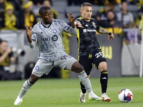 L'attaquant du CF Montréal Kwadwo Opoku, à gauche, passe devant le milieu de terrain du Crew Alexandru Matan lors de la première mi-temps à Columbus dimanche.