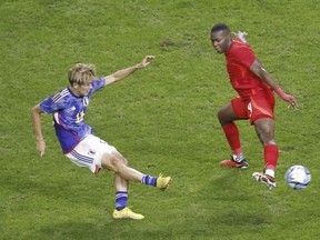 Keito Nakamura, à gauche, du Japon, tire devant Kamal Miller du Canada lors d'un match de football amical à Niigata, dans le nord du Japon, le vendredi 13 octobre 2023. LA PRESSE CANADIENNE/AP-Kyodo News via AP