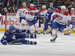 Jake Evans #71 des Canadiens de Montréal passe devant TJ Brodie #78 des Maple Leafs de Toronto tombé à la ligne bleue pendant la première période d'un match de la LNH au Scotiabank Arena le 11 octobre 2023 à Toronto.