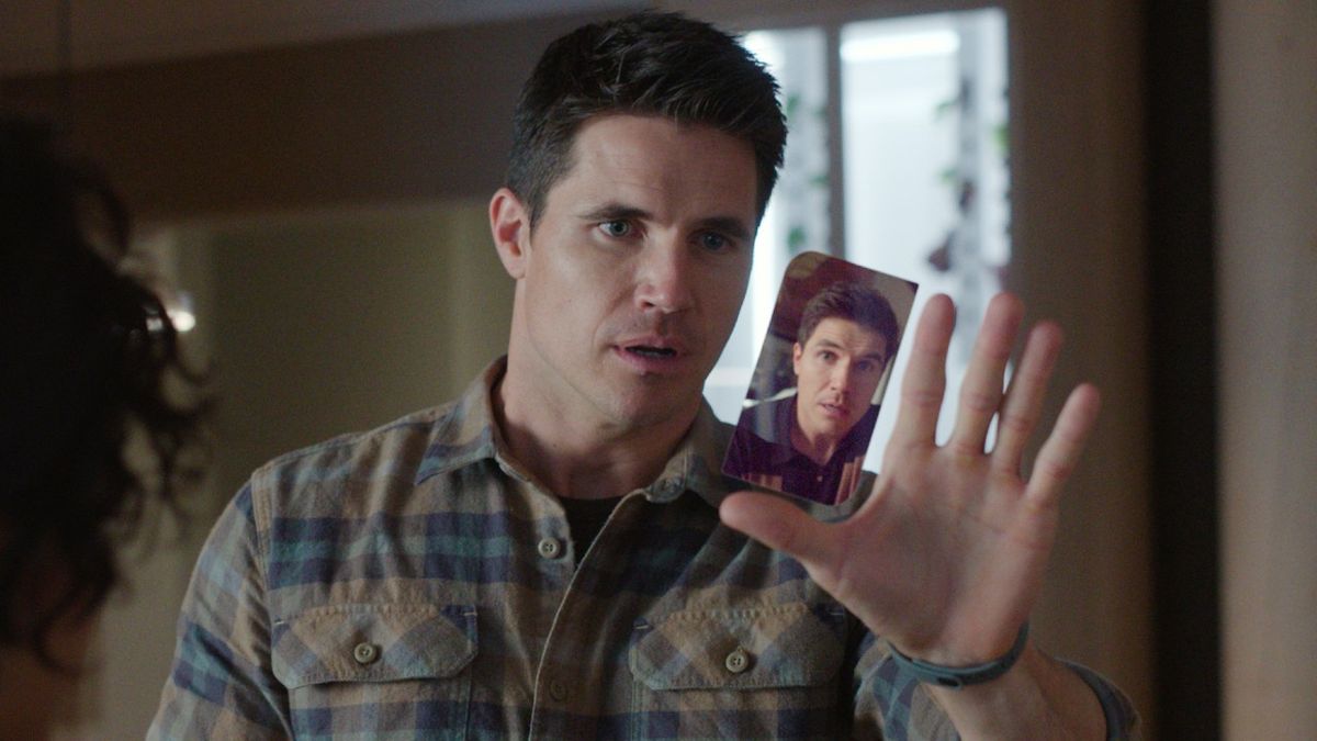 A press image of Robbie Amell as Nathan looking at Nathan on his phone in Upload.