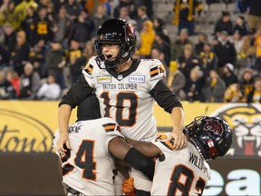 Le botteur des Lions de la Colombie-Britannique Sean Whyte, au centre, est hissé par ses coéquipiers Patrice Rene, à gauche, et Terry Williams après avoir marqué un panier gagnant pour vaincre les Tiger-Cats de Hamilton lors d'un match de football de la LCF à Hamilton, en Ontario.  le vendredi 13 octobre 2023.