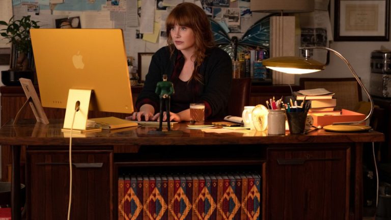 Bryce Dallas Howard working hard at her cluttered desk in Argylle.