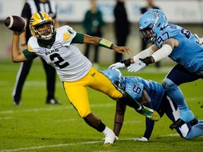 Le quart-arrière des Elks d'Edmonton, Tre Ford (2), subit la pression du demi défensif des Argonauts de Toronto Adarius Pickett (6) et du joueur de ligne défensive Thomas Costigan (97) lors de la deuxième mi-temps d'un match de football de la LCF à Toronto, le vendredi 6 octobre 2023.