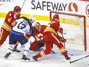 Le gardien des Flames de Calgary Jacob Markstrom affronte les Jets de Winnipeg Gabriel Vilardi en première période du match d'ouverture à domicile au Scotiabank Saddledome de Calgary le mercredi 11 octobre 2023.