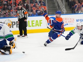 Connor McDavid (97 ans) des Oilers d'Edmonton tire la rondelle devant le gardien des Canucks de Vancouver Casey DeSmith (29 ans) lors de la première période d'action préparatoire de la LNH, le mercredi 27 septembre 2023 à Edmonton.