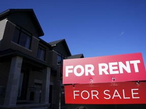 Des pancartes à louer et à vendre sont affichées sur une maison dans un nouveau lotissement à Ottawa le vendredi 14 octobre 2022.