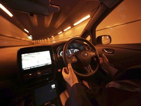 Le directeur général de Nissan Motor Co., Tetsuya Iijima, ne touche pas au volant d'un prototype de véhicule autonome lors d'un essai routier à Tokyo, le mardi 3 novembre 2015.